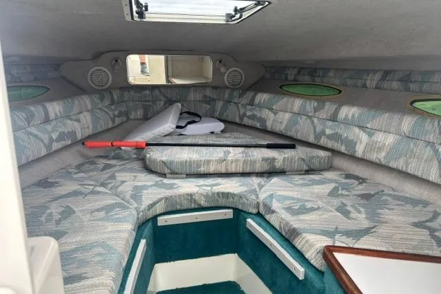 Slide: The Image of 1994 Sea Ray 240 cabin interior with patterned cushions and overhead hatch. - 19