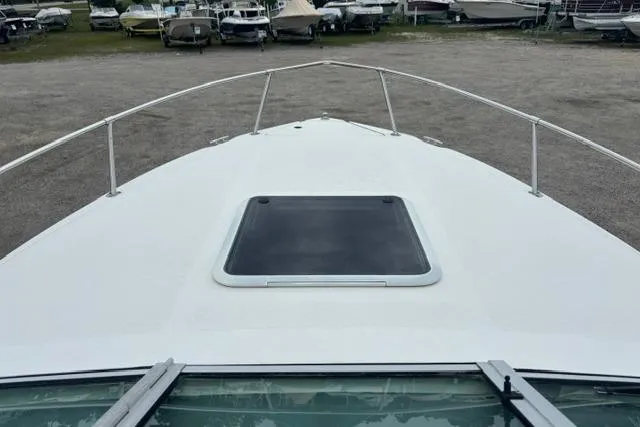 Slide: The Image of 1994 Sea Ray 240 boat deck with hatch, parked among other boats. - 20