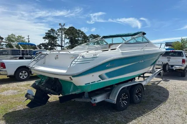 Slide: The Image of 1994 Sea Ray 240 boat on trailer, parked outdoors under clear sky. - 3