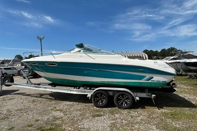 Slide: The Image of 1994 Sea Ray 240 boat on trailer under clear blue sky. - 6