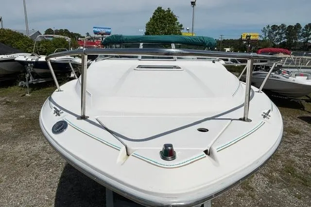 Slide: The Image of 1994 Sea Ray 240 boat with white deck, stainless steel railings, and green canopy. - 9
