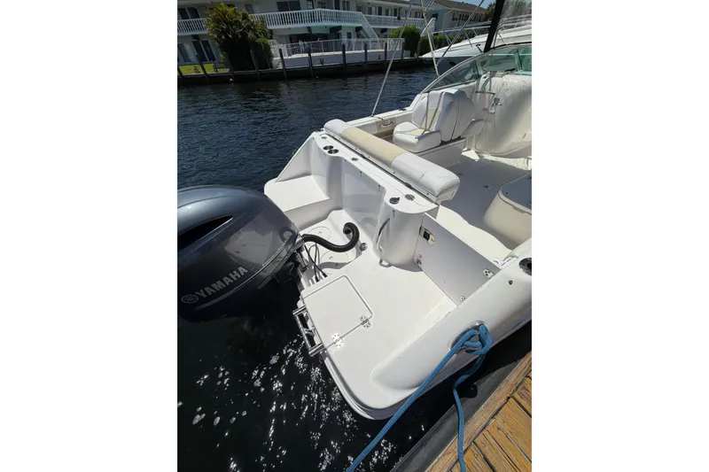 Slide: The Image of 2015 Robalo R227 Dual Console boat with Yamaha engine docked by waterfront homes. - 10