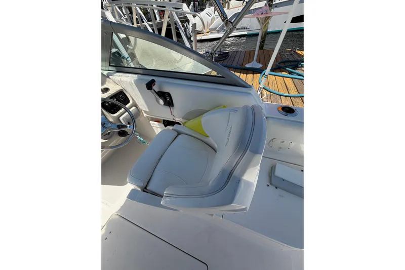 Slide: The Image of 2015 Robalo R227 Dual Console boat interior with white seating and steering wheel. - 14