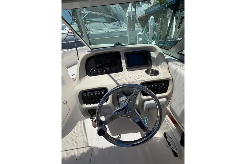 Slide: The Image of 2015 Robalo R227 Dual Console boat dashboard with steering wheel and control panel. - 15