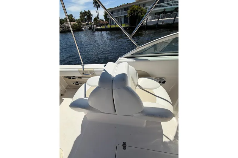 Slide: The Image of 2015 Robalo R227 Dual Console boat interior with white seating by the water. - 16