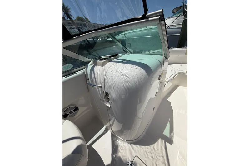 Slide: The Image of 2015 Robalo R227 Dual Console boat interior with sleek white design and windshield. - 17