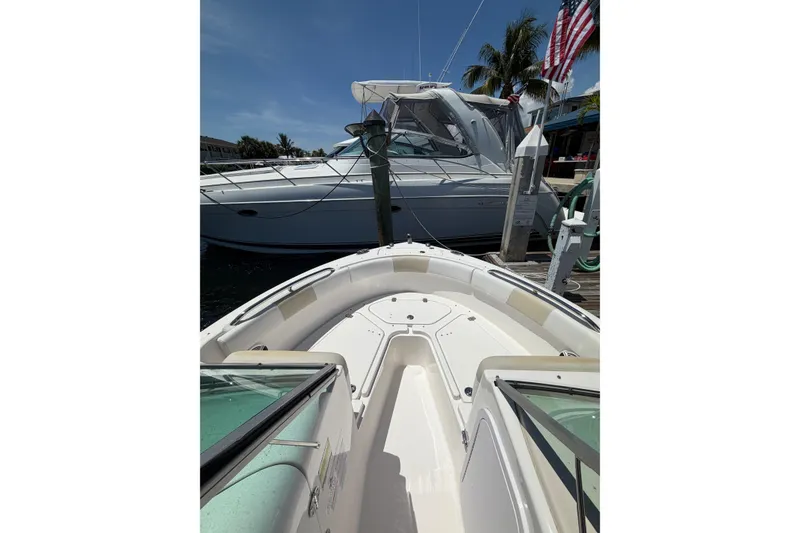 Slide: The Image of 2015 Robalo R227 Dual Console boat docked near a larger vessel. - 19