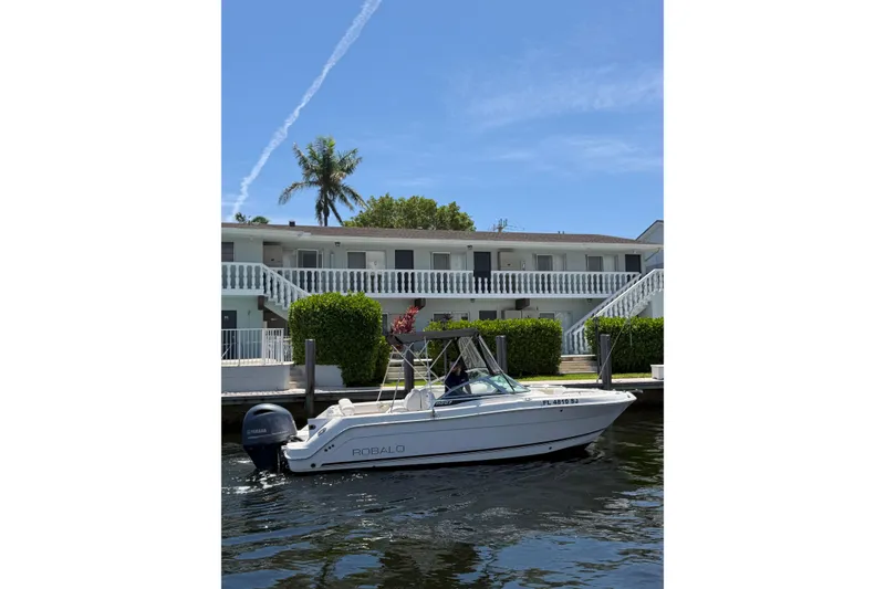 Slide: The Image of 2015 Robalo R227 Dual Console boat docked near waterfront property. - 3
