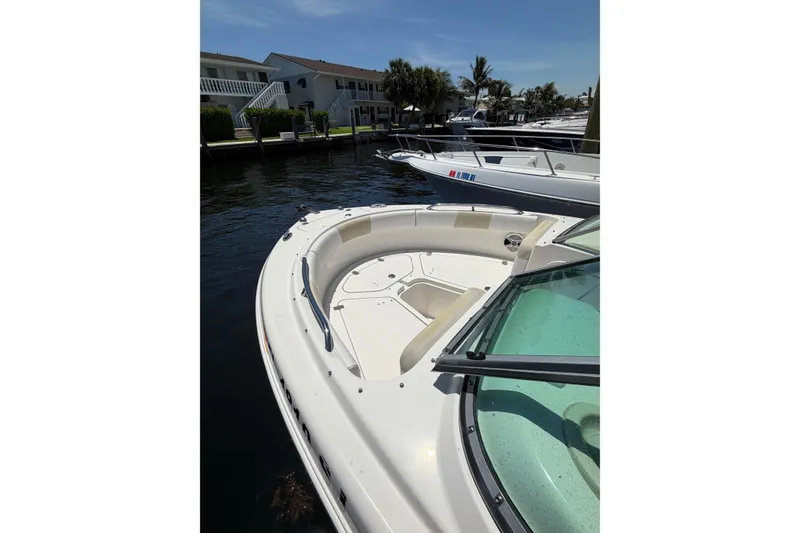 Slide: The Image of 2015 Robalo R227 Dual Console boat docked in a sunny marina. - 31