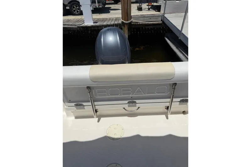 Slide: The Image of 2015 Robalo R227 Dual Console boat stern with outboard motor at dock. - 33