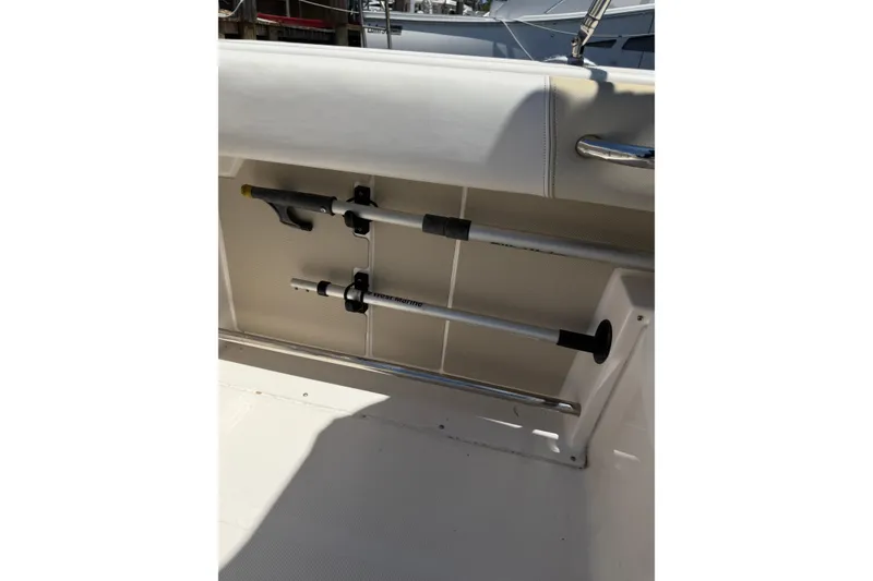 Slide: The Image of 2015 Robalo R227 Dual Console boat interior with mounted fishing rods. - 36