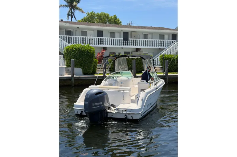 Slide: The Image of 2015 Robalo R227 Dual Console boat docked, featuring Yamaha outboard motor. - 4