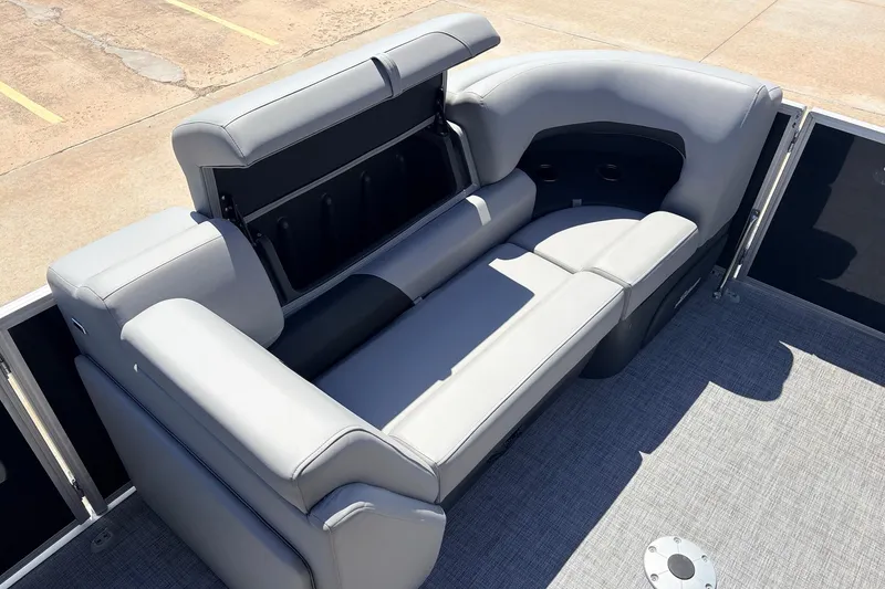 Slide: The Image of 2026 Sun Tracker Party Barge 22 DLX interior with gray seating and storage compartment. - 13