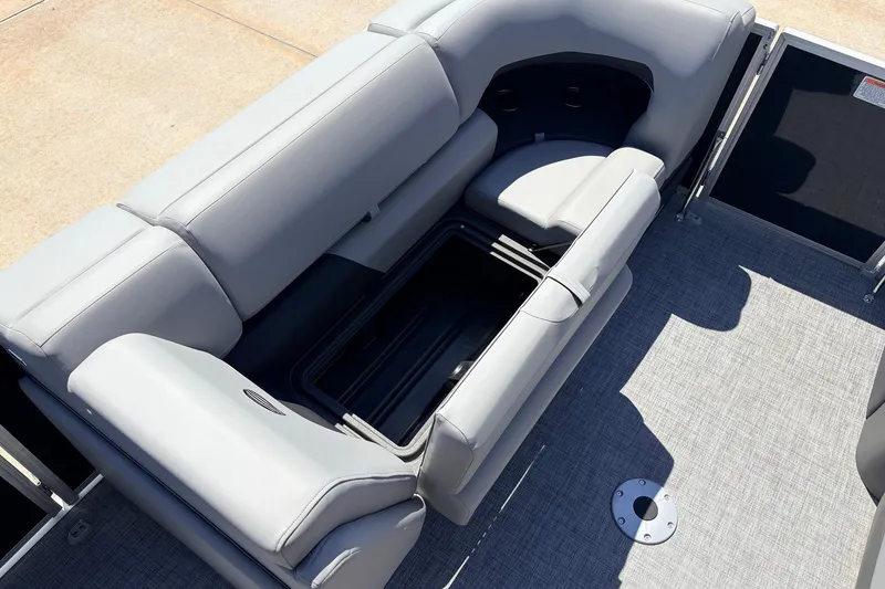 Slide: The Image of 2026 Sun Tracker Party Barge 22 DLX interior with gray seating and storage compartment. - 14