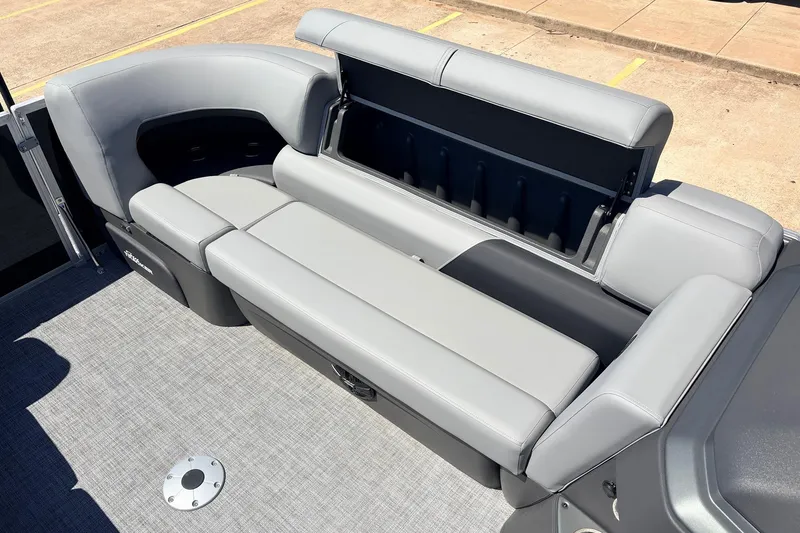 Slide: The Image of 2026 Sun Tracker Party Barge 22 DLX with open storage compartment and gray seating. - 21