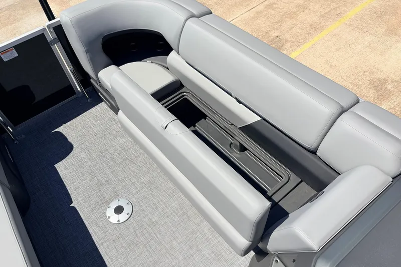Slide: The Image of 2026 Sun Tracker Party Barge 22 DLX interior with gray seating and storage compartment. - 22