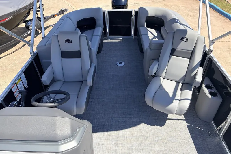 Slide: The Image of 2026 Sun Tracker Party Barge 22 DLX interior with gray seating and steering wheel. - 27