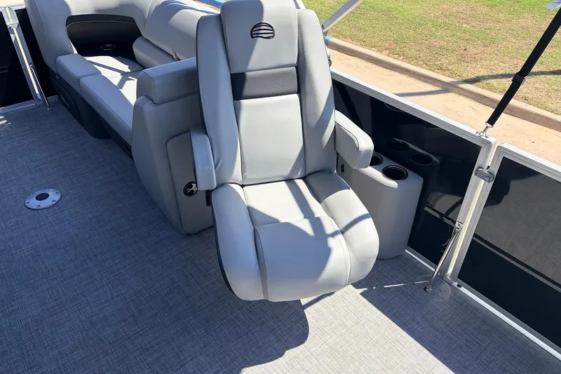 Slide: The Image of 2026 Sun Tracker Party Barge 22 DLX interior with gray seating and cup holders. - 28