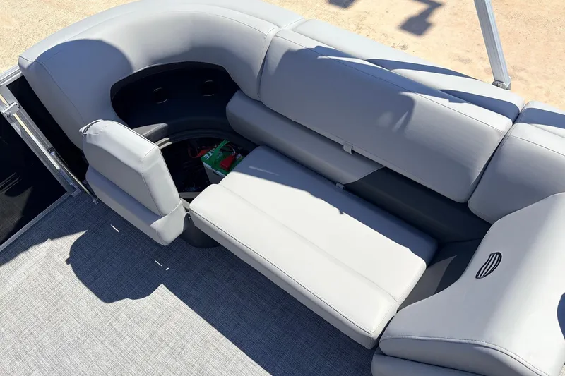 Slide: The Image of 2026 Sun Tracker Party Barge 22 DLX interior with gray seating and storage compartment. - 40