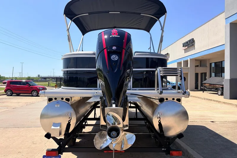 Slide: The Image of 2026 Sun Tracker Party Barge 22 DLX pontoon boat with outboard motor, parked outside dealership. - 7