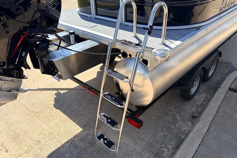 Slide: The Image of 2026 Sun Tracker Party Barge 22 DLX with ladder and outboard motor on trailer. - 9