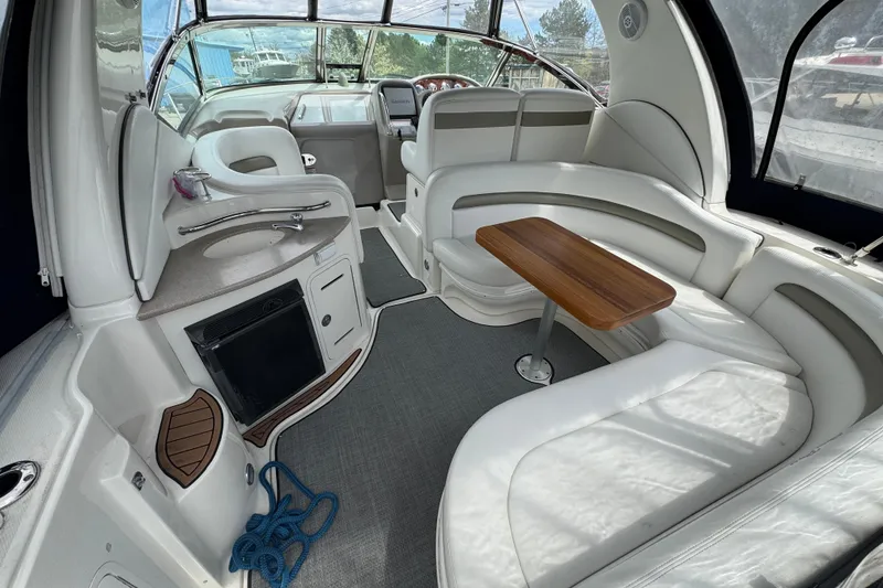 Slide: The Image of 2007 Sea Ray Sundancer 320 interior with white seating, wooden table, and compact kitchenette. - 10