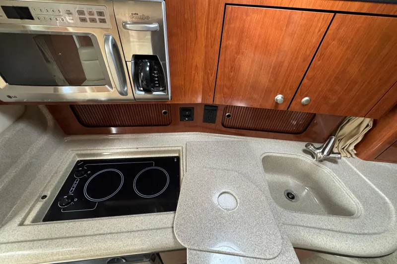 Slide: The Image of 2007 Sea Ray Sundancer 320 kitchen with microwave, stovetop, and sink. - 14
