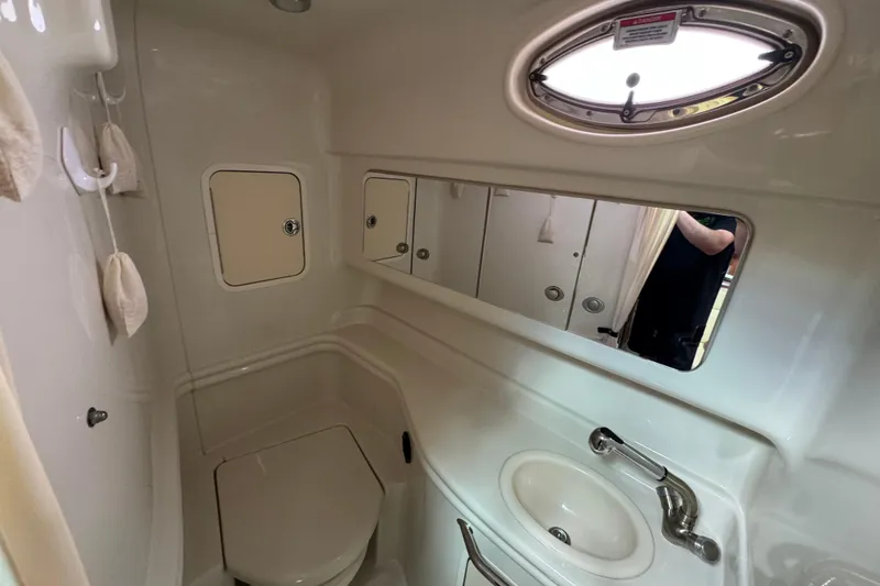 Slide: The Image of Compact bathroom in a 2007 Sea Ray Sundancer 320 yacht, featuring a toilet, sink, and mirror. - 5