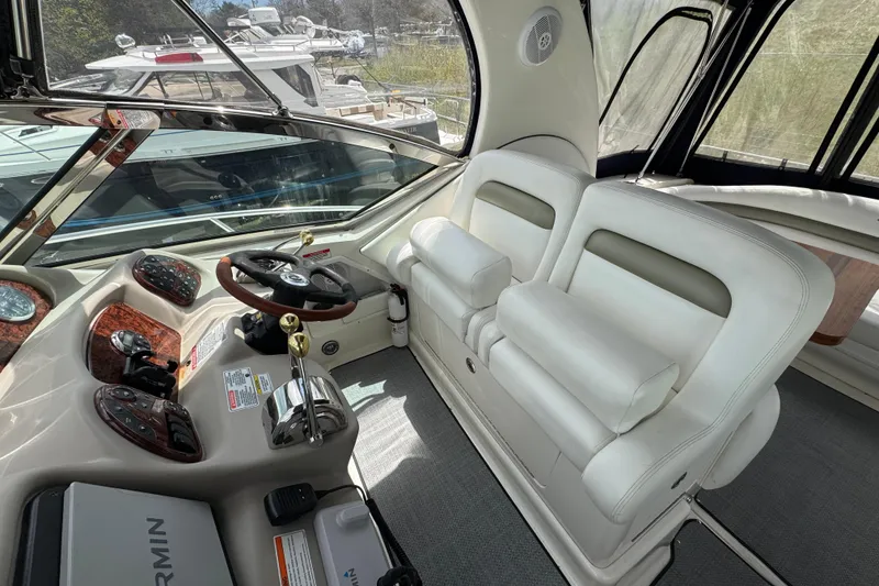 Slide: The Image of 2007 Sea Ray Sundancer 320 cockpit with dual white leather seats and modern control panel. - 6