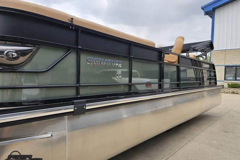 Slide: The Image of 2026 Landau Signature 25C pontoon boat parked outside a building. - 21