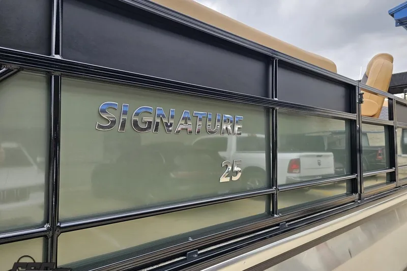 Slide: The Image of 2026 Landau Signature 25C pontoon boat with sleek design and metallic lettering. - 22