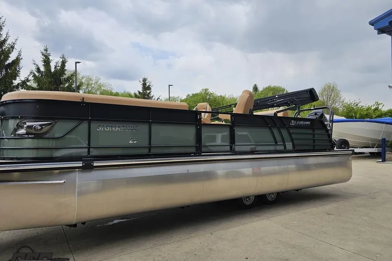 Slide: The Image of 2026 Landau Signature 25C pontoon boat parked outdoors on a cloudy day. - 23