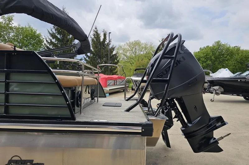 Slide: The Image of 2026 Landau Signature 25C pontoon boat with Suzuki outboard motor, docked outdoors. - 29