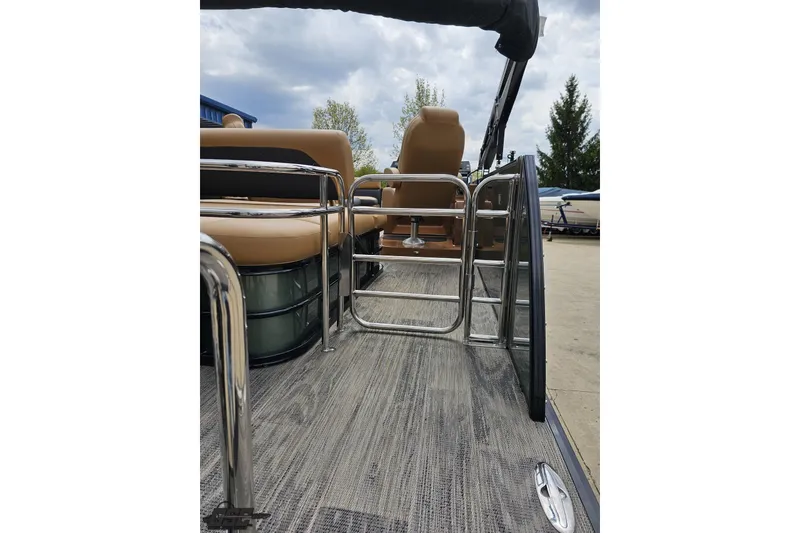 Slide: The Image of 2026 Landau Signature 25C pontoon boat interior with tan seating and metal railings. - 37