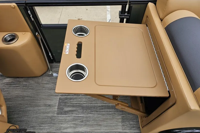 Slide: The Image of 2026 Landau Signature 25C boat interior with tan foldable table and cup holders. - 59