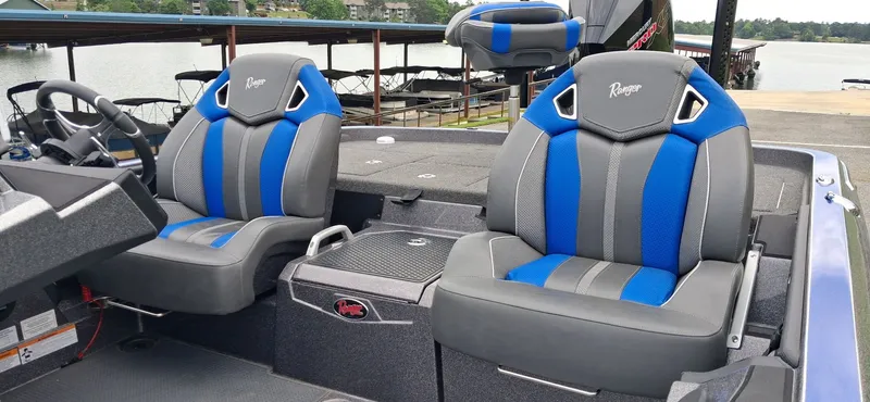 Slide: The Image of 2024 Ranger Z521R boat with blue and gray seats by the lake. - 8