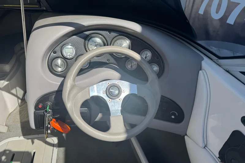 Slide: The Image of Steering wheel and dashboard of a 2006 Ebbtide 190 SE boat, featuring gauges and controls. - 11