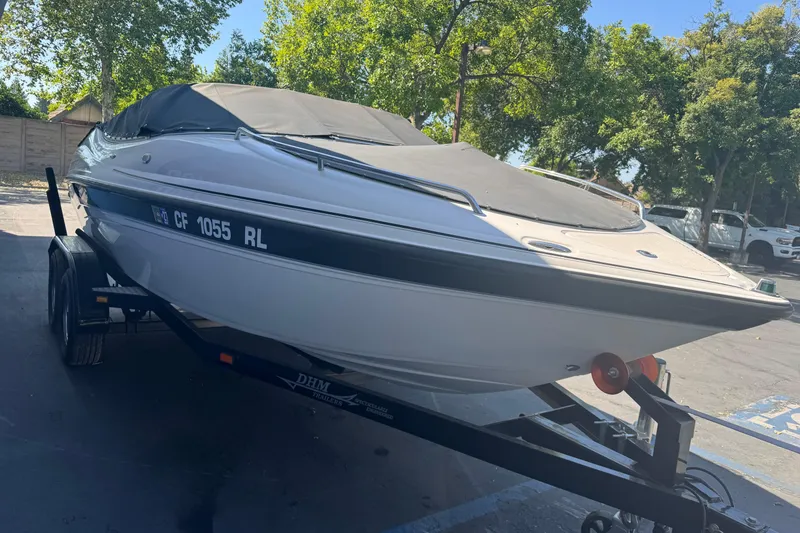 Slide: The Image of 2006 Ebbtide 190 SE boat on trailer, parked outdoors with trees in background. - 4