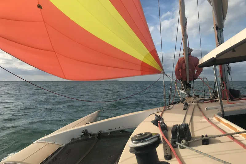 Slide: The Image of Sailing on a 1989 Corsair F27 trimaran with vibrant orange and yellow sails. - 4