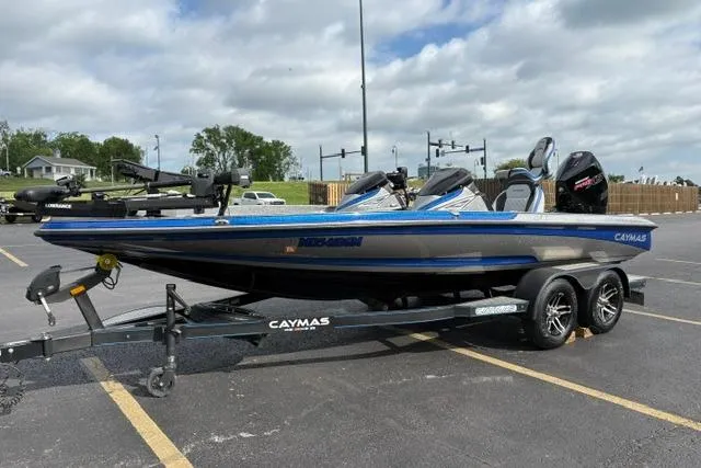 Slide: The Image of 2021 Caymas CX 19 boat on trailer in parking lot, under cloudy sky. - 10