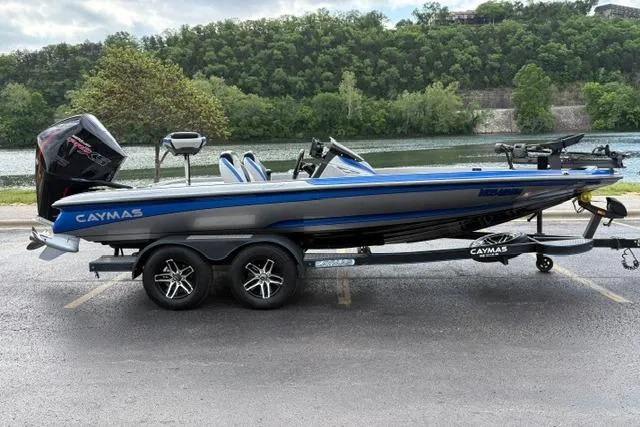Slide: The Image of 2021 Caymas CX 19 boat on trailer by a scenic riverside with lush greenery. - 12