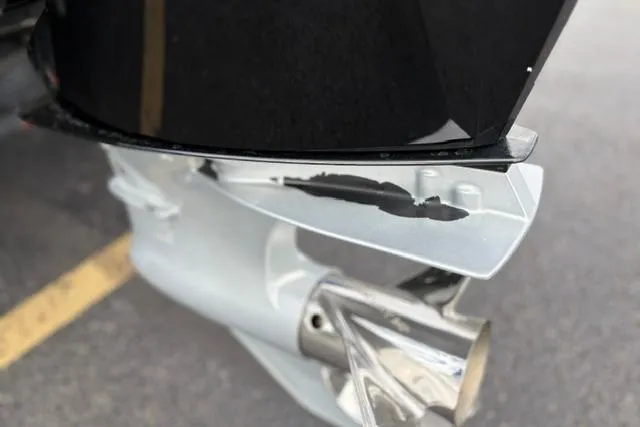 Slide: The Image of Close-up of a 2021 Caymas CX 19 boat motor with visible damage. - 17