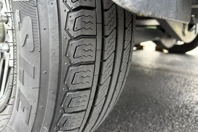 Slide: The Image of Close-up of a 2021 Caymas CX 19 tire tread on a textured surface. - 19
