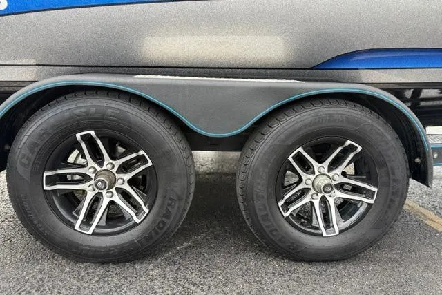Slide: The Image of 2021 Caymas CX 19 trailer wheels with stylish black and silver rims on asphalt. - 20