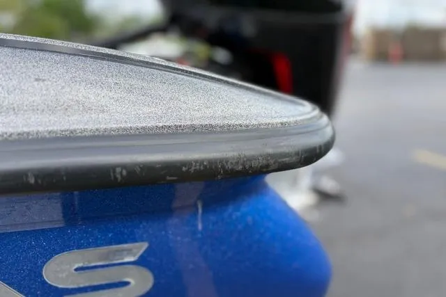 Slide: The Image of Close-up of a 2021 Caymas CX 19 boat's blue hull with sleek design details. - 25