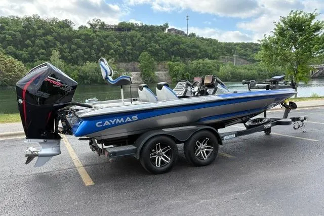 Slide: The Image of 2021 Caymas CX 19 boat on trailer by a scenic riverside, featuring sleek design and powerful engine. - 3