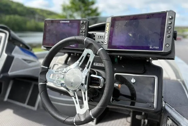 Slide: The Image of 2021 Caymas CX 19 boat dashboard with dual Lowrance fish finders and sleek steering wheel. - 34