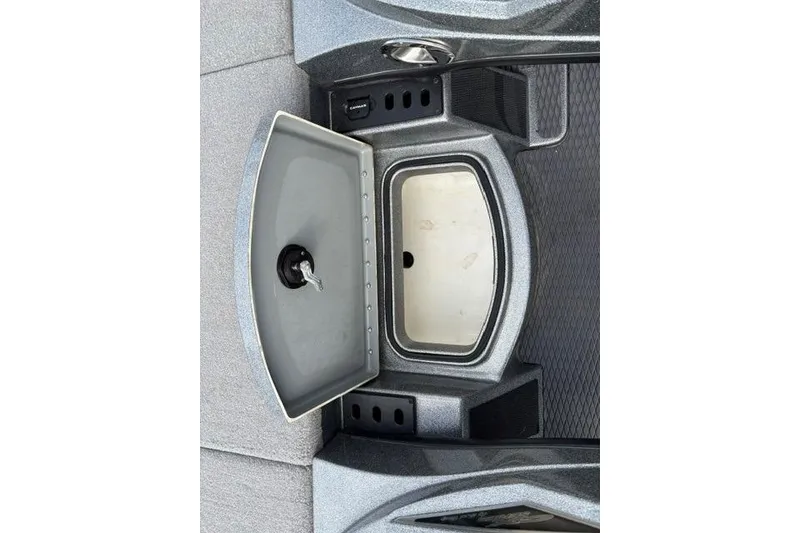 Slide: The Image of 2021 Caymas CX 19 boat storage compartment with open lid and key. - 43