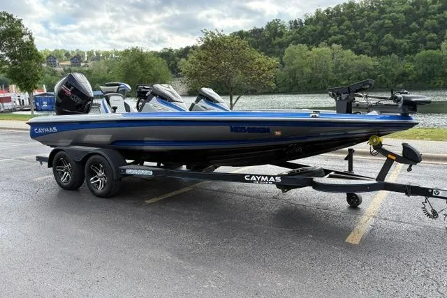 Slide: The Image of 2021 Caymas CX 19 boat on trailer by a scenic lake backdrop. - 5
