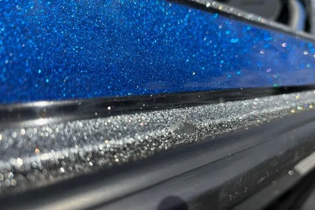 Slide: The Image of Close-up of 2021 Caymas CX 19 boat with sparkling blue and silver finish. - 60